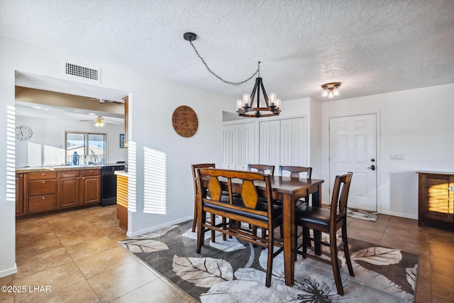 dining room featuring light tile patterned floors, baseboards, visible vents, and a textured ceiling