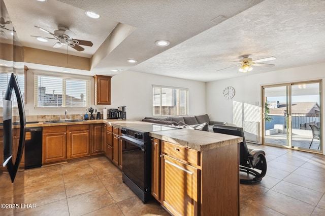 kitchen featuring a sink, electric range, a peninsula, and brown cabinetry