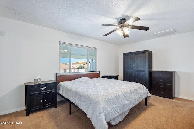 bedroom with visible vents, baseboards, light colored carpet, and a textured ceiling