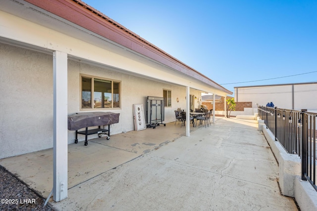 view of patio with outdoor dining space and fence