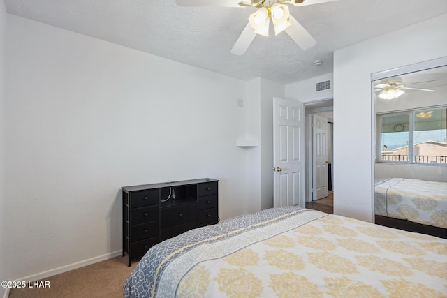 carpeted bedroom with visible vents, baseboards, a textured ceiling, and ceiling fan