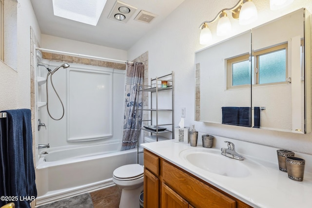 bathroom featuring visible vents, toilet, a skylight, shower / tub combo, and vanity