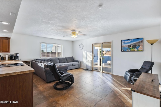 living room with dark tile patterned floors, a textured ceiling, recessed lighting, baseboards, and ceiling fan