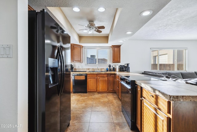 kitchen with a sink, plenty of natural light, black appliances, and a peninsula