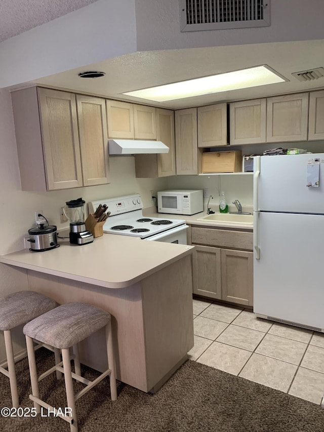 1989 Mesquite Ave Unit 2, Lake Havasu City, AZ 86403 - kitchen featuring white appliances, a sink, under cabinet range hood, a peninsula, and a kitchen breakfast bar