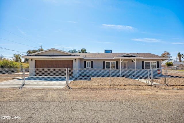 ranch-style house featuring a garage, concrete driveway, a fenced front yard, and stucco siding