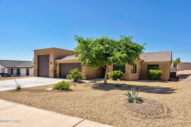 adobe home with a garage and central air condition unit