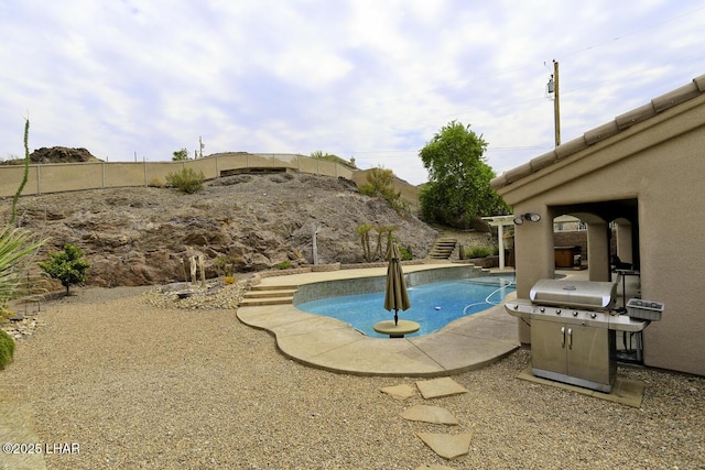 outdoor pool featuring a fenced backyard and a grill