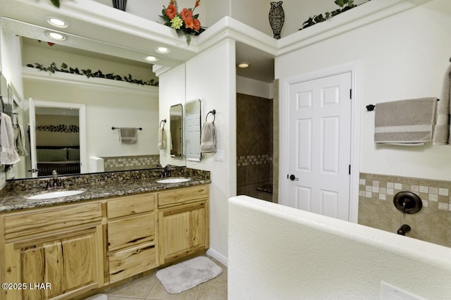 bathroom featuring walk in shower, connected bathroom, tile patterned floors, and a sink