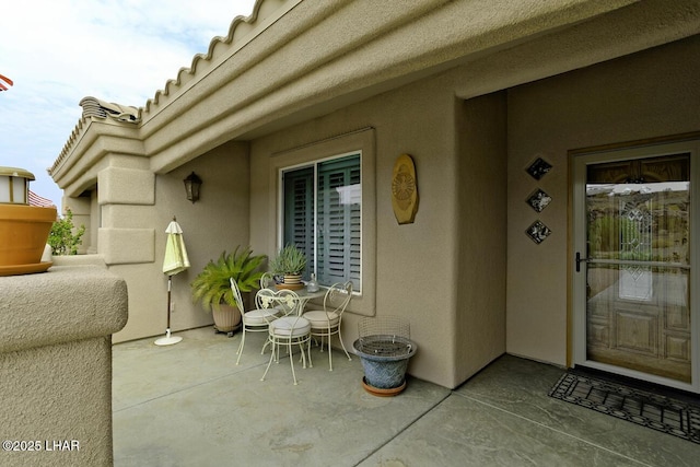 entrance to property with a patio area and stucco siding