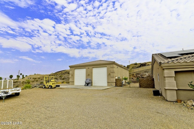 detached garage with roof mounted solar panels and fence