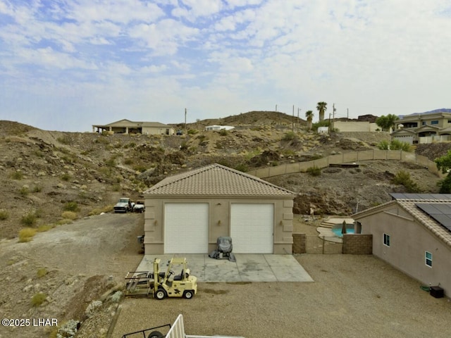 detached garage featuring fence and a mountain view