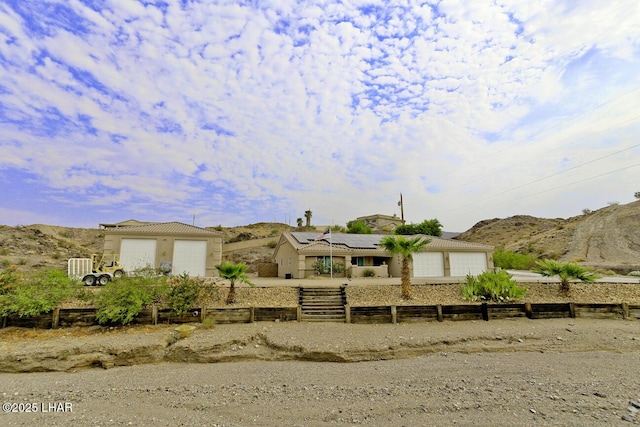 view of front of house featuring a tiled roof, roof mounted solar panels, a mountain view, and a fenced front yard