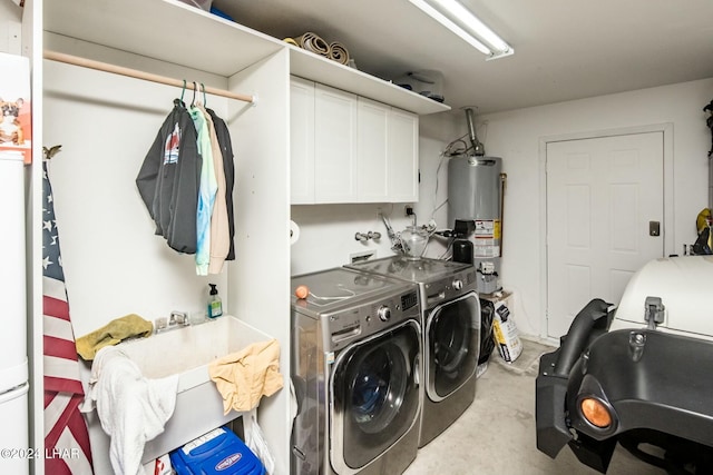 laundry room with cabinets, gas water heater, and washing machine and clothes dryer