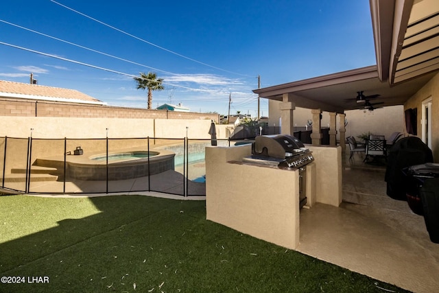 view of yard featuring exterior kitchen, a patio, a swimming pool with hot tub, and ceiling fan