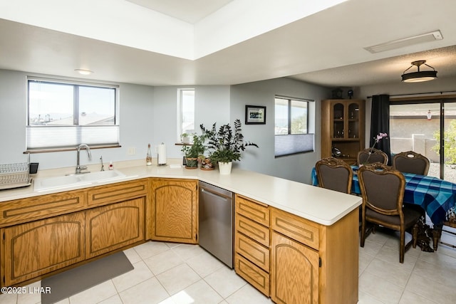 kitchen featuring a peninsula, a sink, visible vents, light countertops, and stainless steel dishwasher