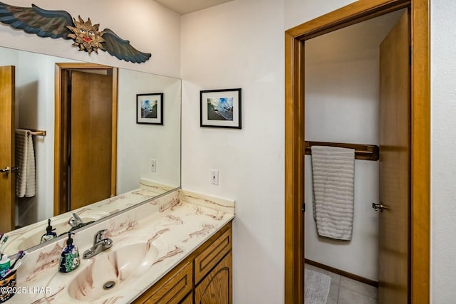 bathroom featuring tile patterned flooring, baseboards, and vanity