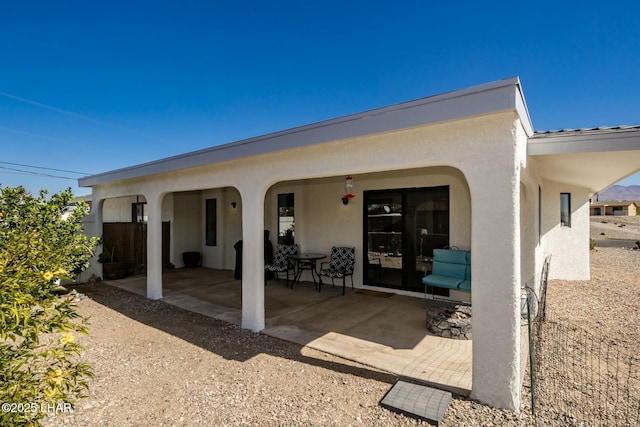 rear view of property with a patio area and stucco siding