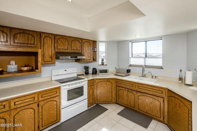 kitchen with electric stove, open shelves, brown cabinetry, a sink, and under cabinet range hood