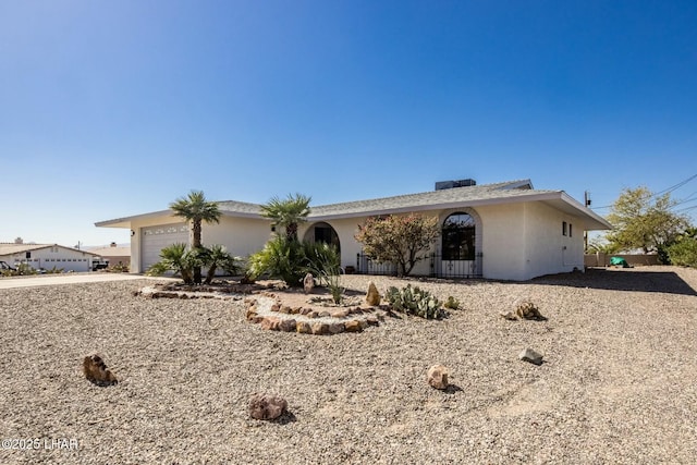 ranch-style home with an attached garage, driveway, and stucco siding