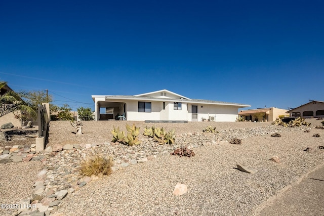 view of front facade featuring an attached carport and stucco siding