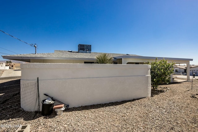 view of side of property with fence and central AC unit