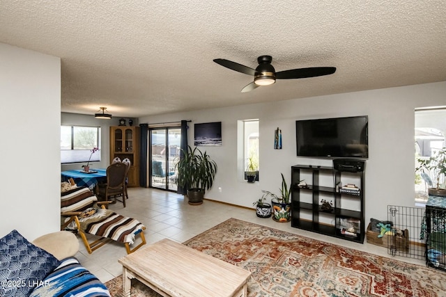 living area featuring a textured ceiling, a ceiling fan, and tile patterned floors