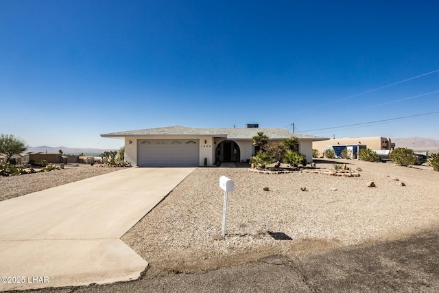 ranch-style home with an attached garage, concrete driveway, and stucco siding