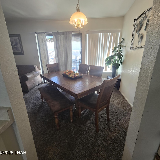 carpeted dining room featuring a notable chandelier