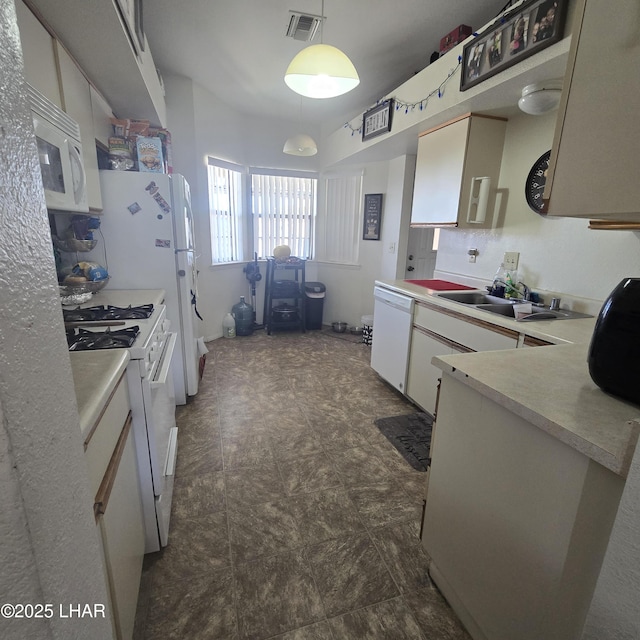 kitchen featuring white cabinetry, hanging light fixtures, white appliances, and sink