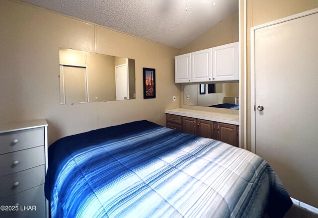 bedroom featuring vaulted ceiling and a textured ceiling