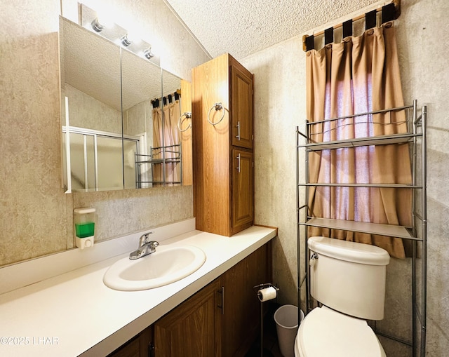 bathroom featuring lofted ceiling, vanity, a textured ceiling, toilet, and walk in shower