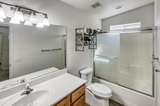 full bathroom featuring toilet, vanity, and bath / shower combo with glass door