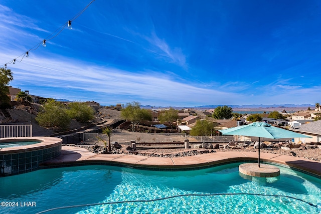 view of swimming pool featuring an in ground hot tub and a mountain view