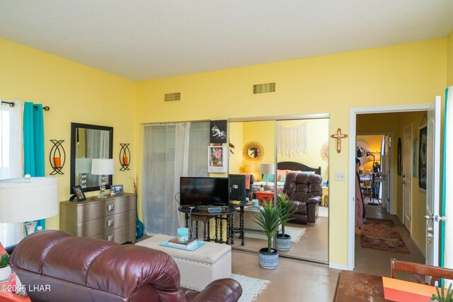 living room featuring visible vents and concrete floors