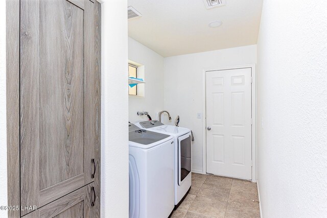 laundry room with light tile patterned flooring and washer and clothes dryer