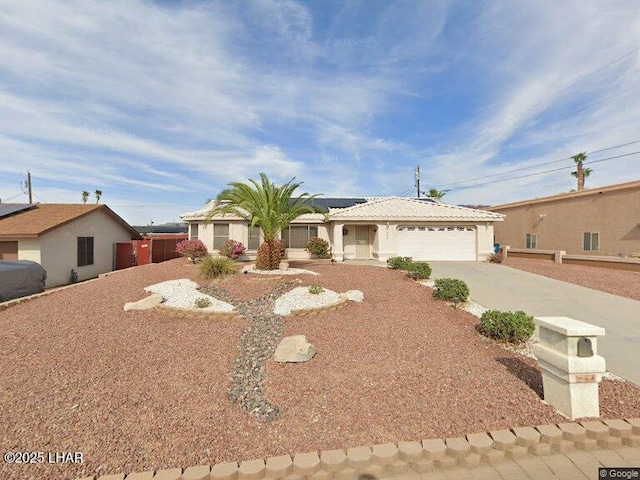 ranch-style house with concrete driveway, an attached garage, and stucco siding