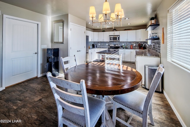 dining space featuring dark hardwood / wood-style floors, sink, and an inviting chandelier