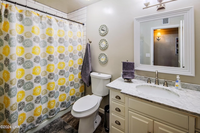 bathroom with walk in shower, vanity, and toilet