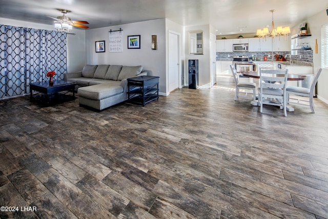 living room featuring ceiling fan with notable chandelier, sink, and hardwood / wood-style floors