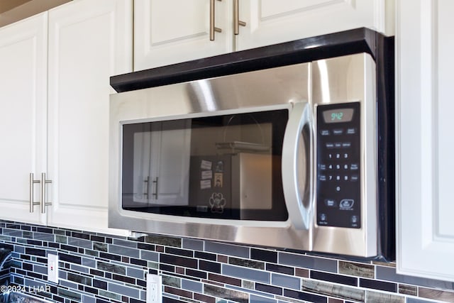 room details with white cabinets and decorative backsplash