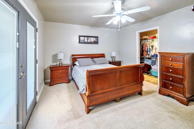 carpeted bedroom featuring a walk in closet, ceiling fan, and a closet