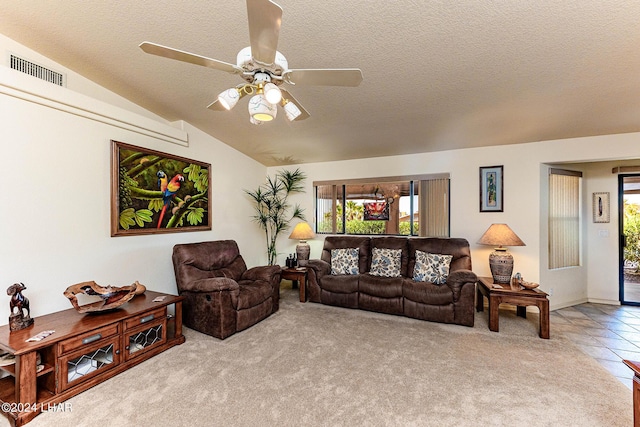 living room featuring ceiling fan, lofted ceiling, light colored carpet, and a textured ceiling