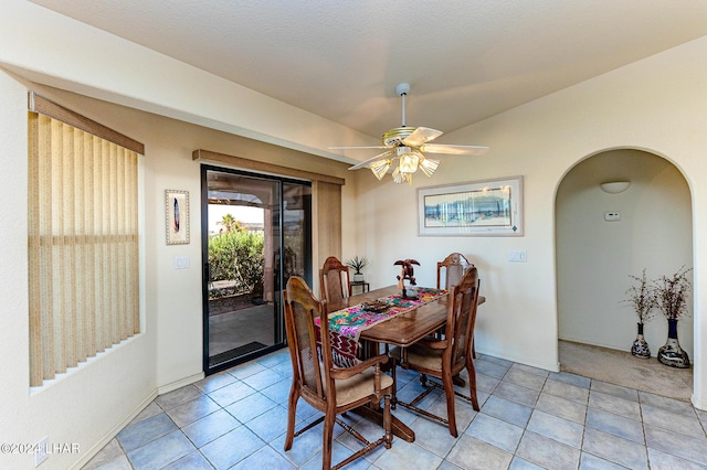 tiled dining area featuring ceiling fan and lofted ceiling