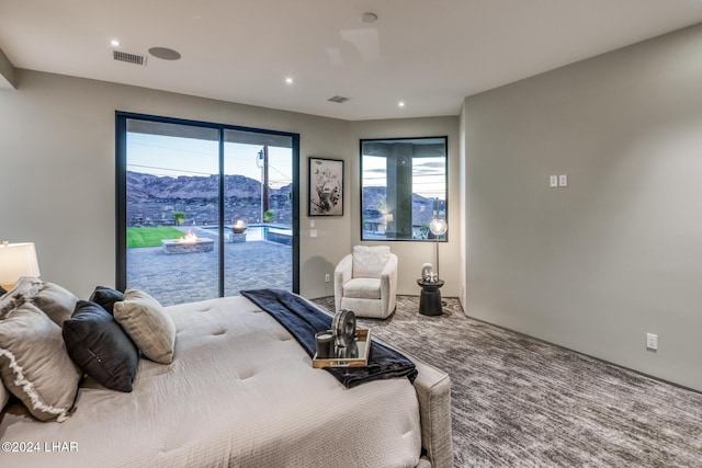 bedroom with a mountain view, carpet floors, and access to exterior