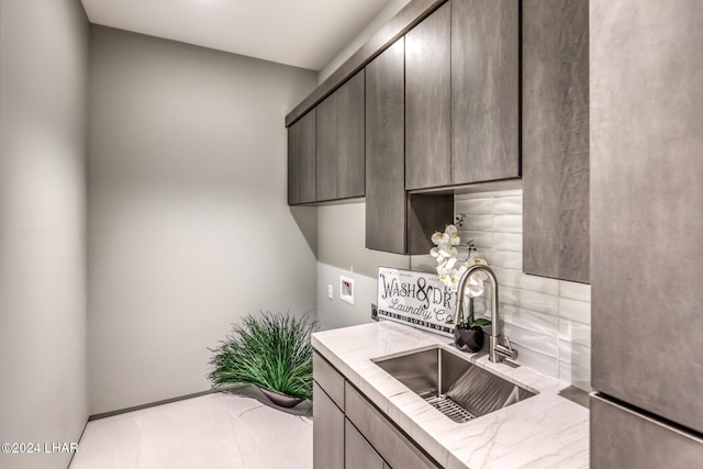 kitchen with stainless steel fridge, dark brown cabinets, sink, and backsplash