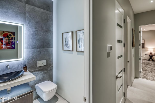 bathroom featuring vanity, toilet, and tile walls