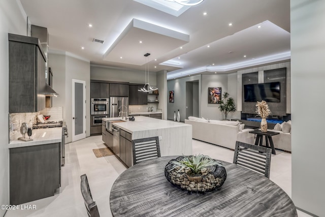 tiled dining space featuring sink and a tray ceiling