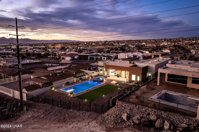 pool at dusk with a patio area