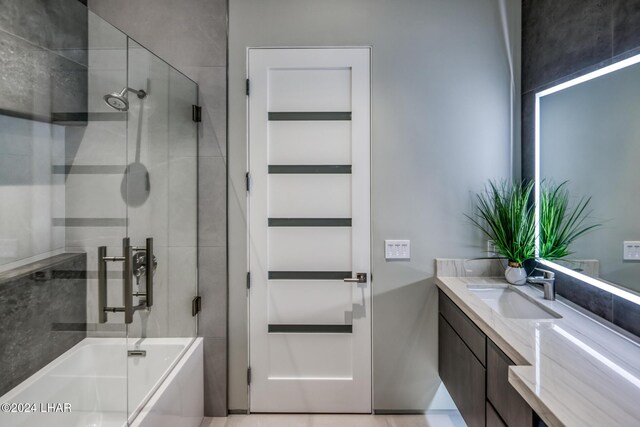 bathroom featuring vanity and shower / bath combination with glass door